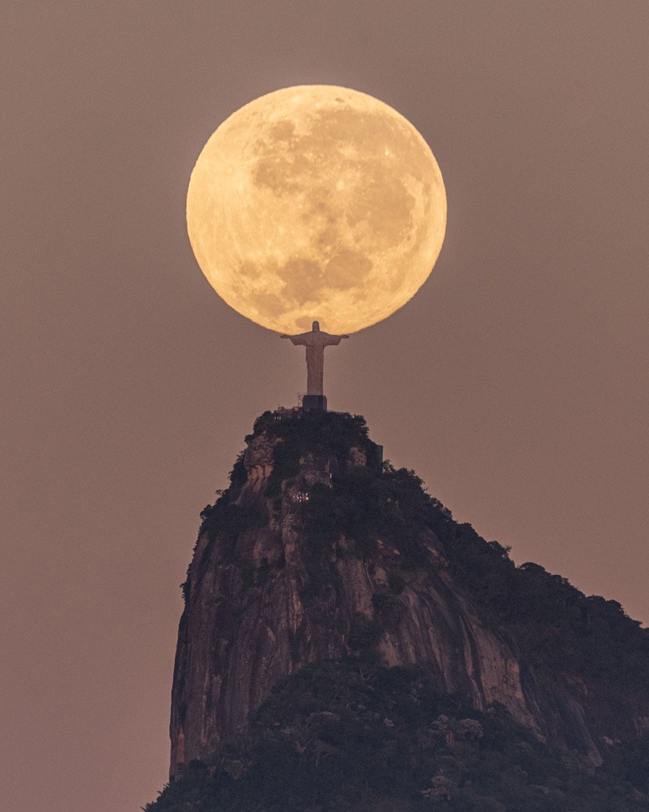 Christ the Redeemer statue overlooking Rio de Janeiro bay at sunset